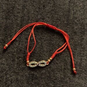 Red infinite bracelet adjustable w/ turquoise beads & Greek eye. Gold plated.
